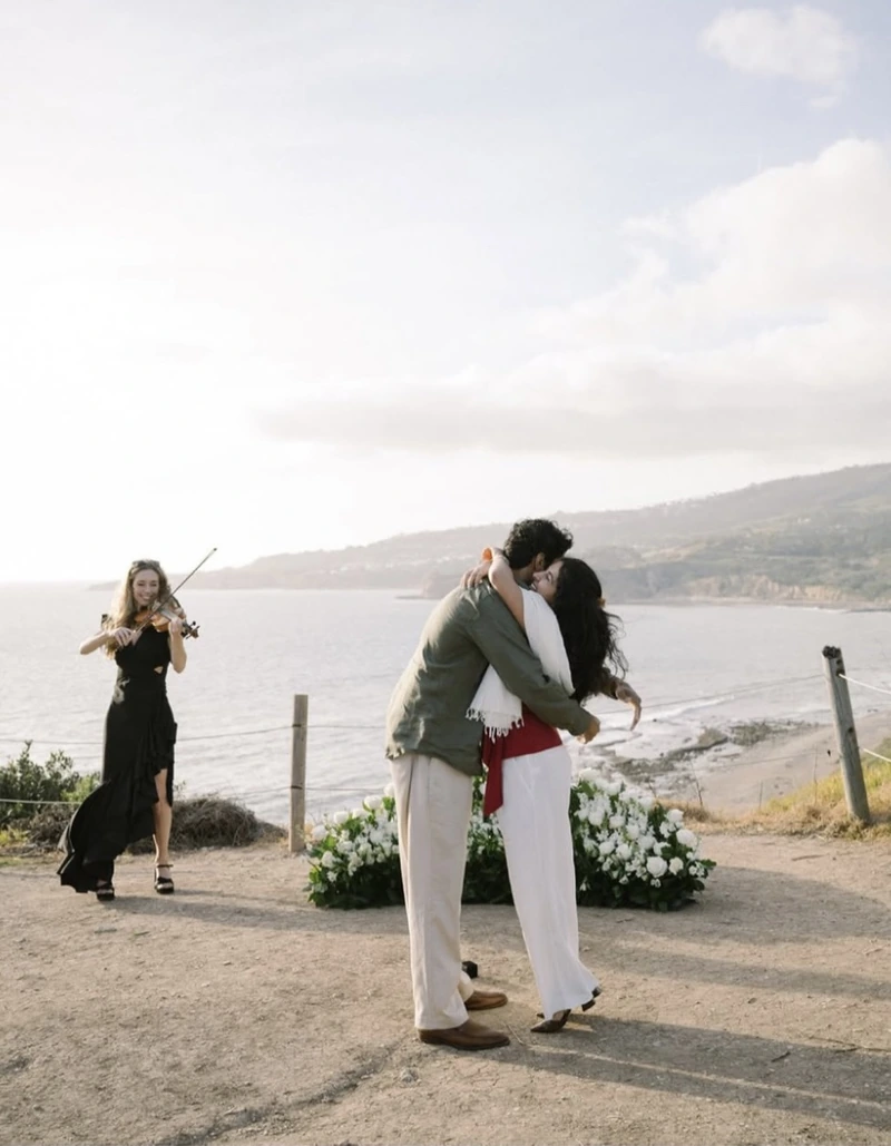 Elin Wolf performing violin during an oceanfront proposal